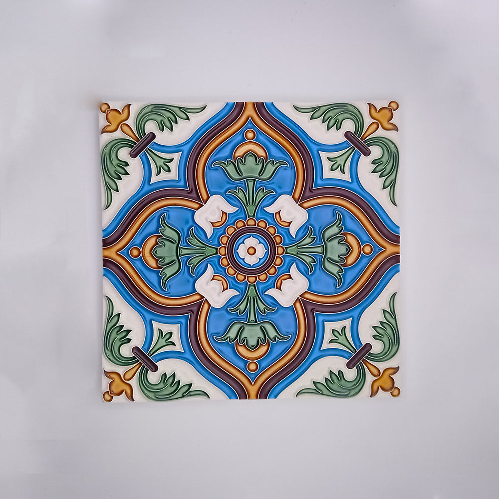A vibrant hand-painted decorative porcelain tile from Tejo Shop with a symmetrical design featuring a central green and orange motif surrounded by blue, green, and white decorative patterns, set on a white background.