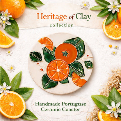 The Algarve Orange Harvest Ceramic Coaster by Miradouro Ceramics is a round, handmade piece featuring vibrant orange fruit and green leaf designs, showcasing Portuguese craftsmanship and inspired by fresh oranges in the Algarve.