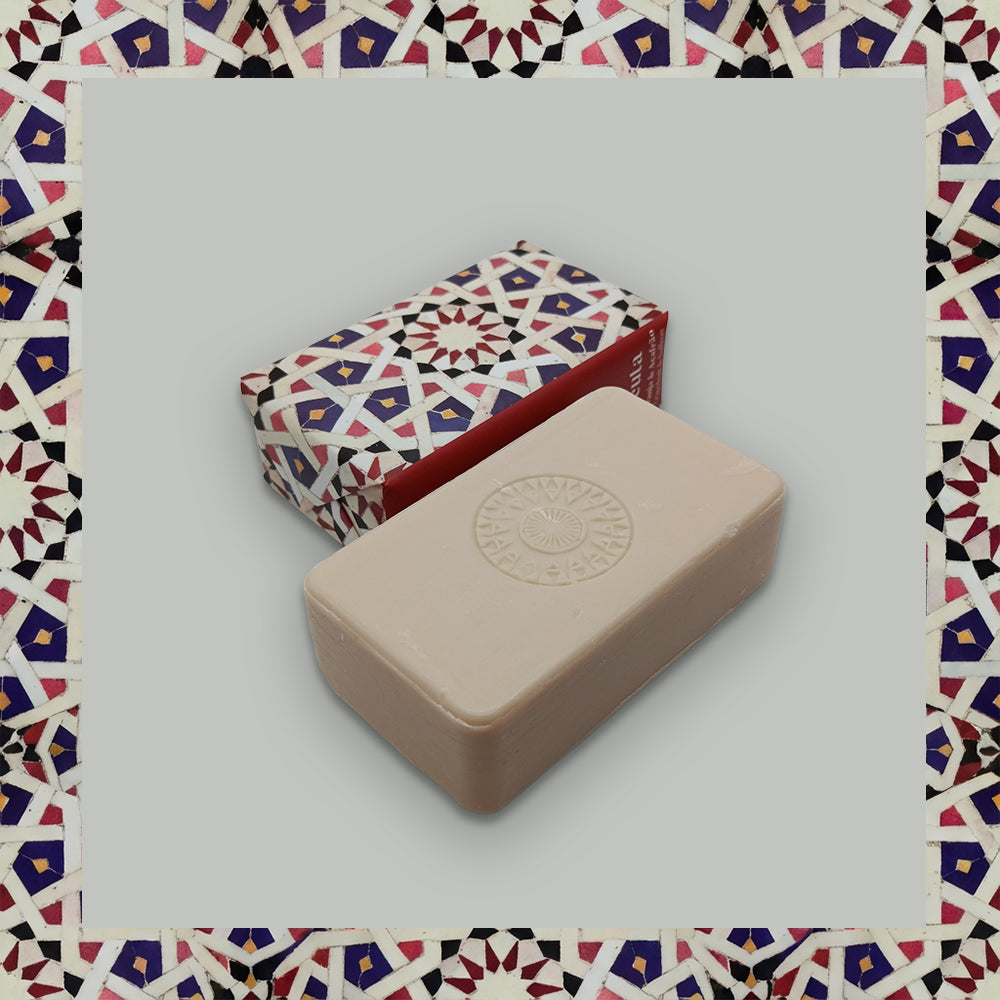 A beige bar of Ceuta 1415 – The First Horizon soap from 100ml, with an embossed circular design, sits before a red and white box. Handcrafted in Portugal, this soap features the Age of Discovery fragrance.