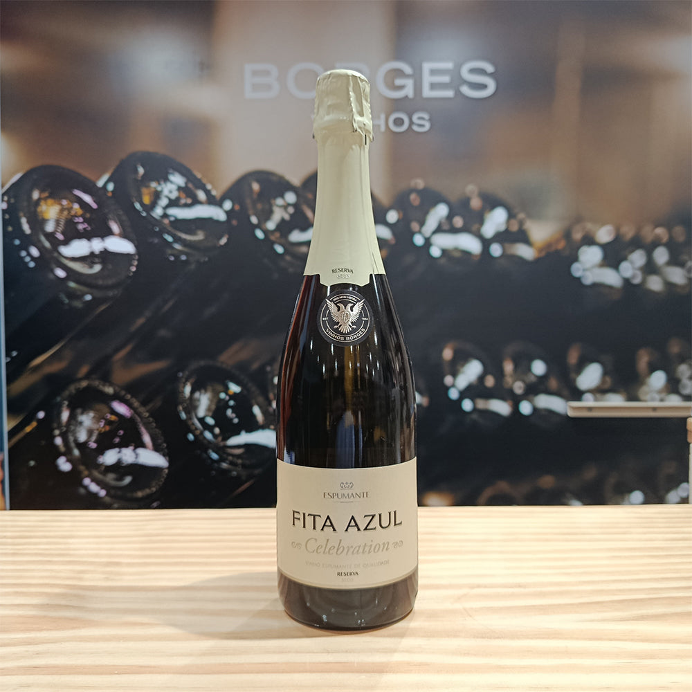 A bottle of Fita Azul Celebration Reserve Dry by Borges Wines stands on a wooden surface, with blurred wine bottles and the brand name "Borges" visible in the background.