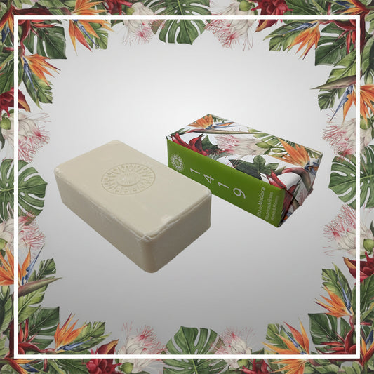 The Ilha da Madeira 1419 – The Atlantic Garden soap by 100ml, a rectangular white bar with Madeira fragrance, is shown beside its floral-patterned box on a background bordered by tropical leaves and flowers.