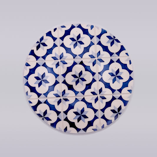 The Tejo Shop Leiria Ceramic Trivet Hot Pad features a pattern of blue and white geometric floral designs against a light background. Hand-made, the floral pattern is repeated in a grid layout, creating a visually intricate arrangement perfect for any kitchen.