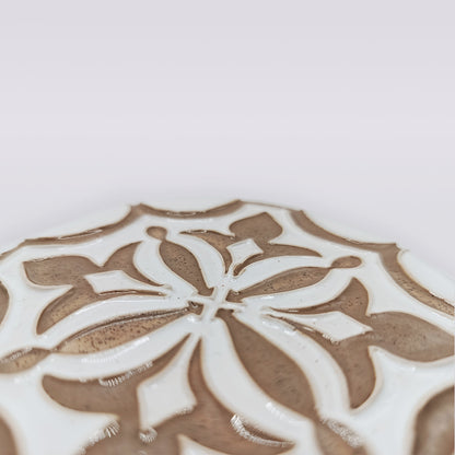 Close-up of Lusitana TerraFleur by Miradouro Ceramics—a handcrafted tile featuring a raised, symmetrical brown and white floral pattern, beautifully illustrating the elegance of Portuguese ceramics.