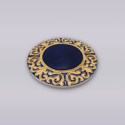 The Manuel I Royal Crest Ceramic Coaster by Miradouro Ceramics features a deep blue center with an ornate gold and blue border, evoking Portuguese style, displayed on a light gray background.