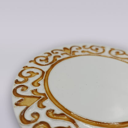 A close-up of the Manueline Golden Crest Ceramic Coaster by Miradouro Ceramics, showcasing its ornate raised gold rim detail, inspired by handcrafted Portuguese design, set against a pale background.