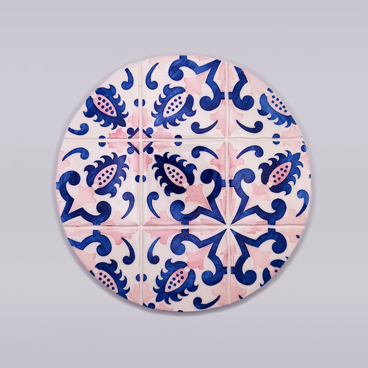 A Tejo Shop Porto Ceramic Trivet for Hot Pots with a symmetrical design featuring intricate blue and pink patterns. The blue elements form swirling shapes and floral motifs, while the pink elements create star-like figures, all set on a white background—perfect for adding a touch of hand-made charm to your kitchen decor.