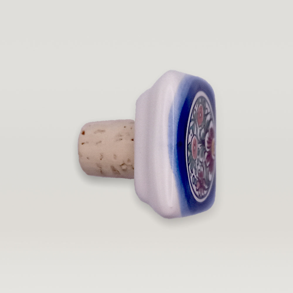 Hand-painted Tejo Shop ceramic bottle stopper with cork on a white background.