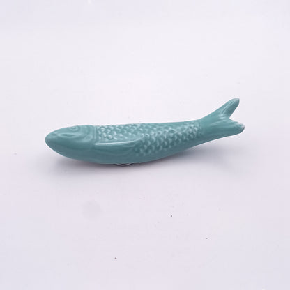 A light blue ceramic chopstick rest shaped like a fish, designed to evoke the charm of the Tejo Shop Ceramic Sardine Fridge Magnet, positioned against a plain white background. Perfect for adding a touch of charm to your kitchen decor.