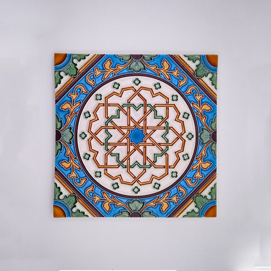 A Tejo Shop hand painted decorative ceramic tile featuring a detailed geometric and floral pattern in shades of green, blue, orange, and white, displayed against a plain light background.