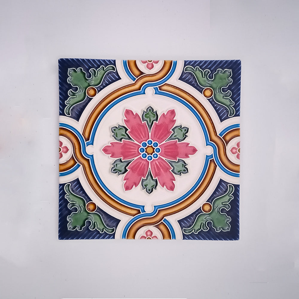 Decorative Backsplash Tile from Tejo Shop featuring a symmetric design with a central floral motif in pink and blue, suitable for use as backsplash tiles, surrounded by swirling patterns and accentuated with green and orange elements.