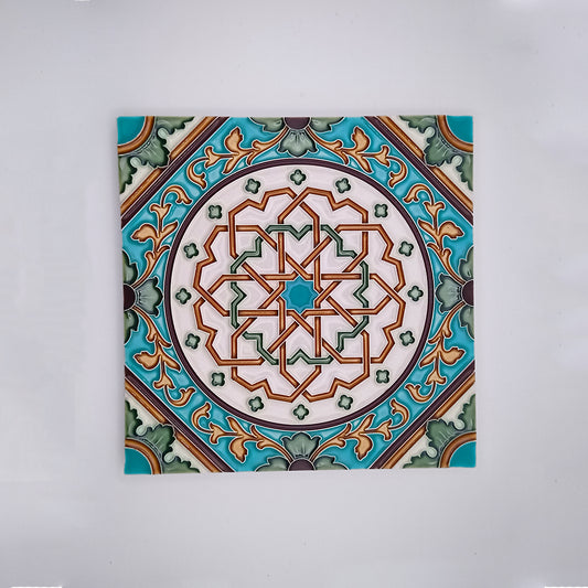 A Moorish Decorative Tile by Tejo Shop featuring a hand-painted symmetrical geometric and floral pattern in shades of green, turquoise, orange, and white, displayed against a plain light background.