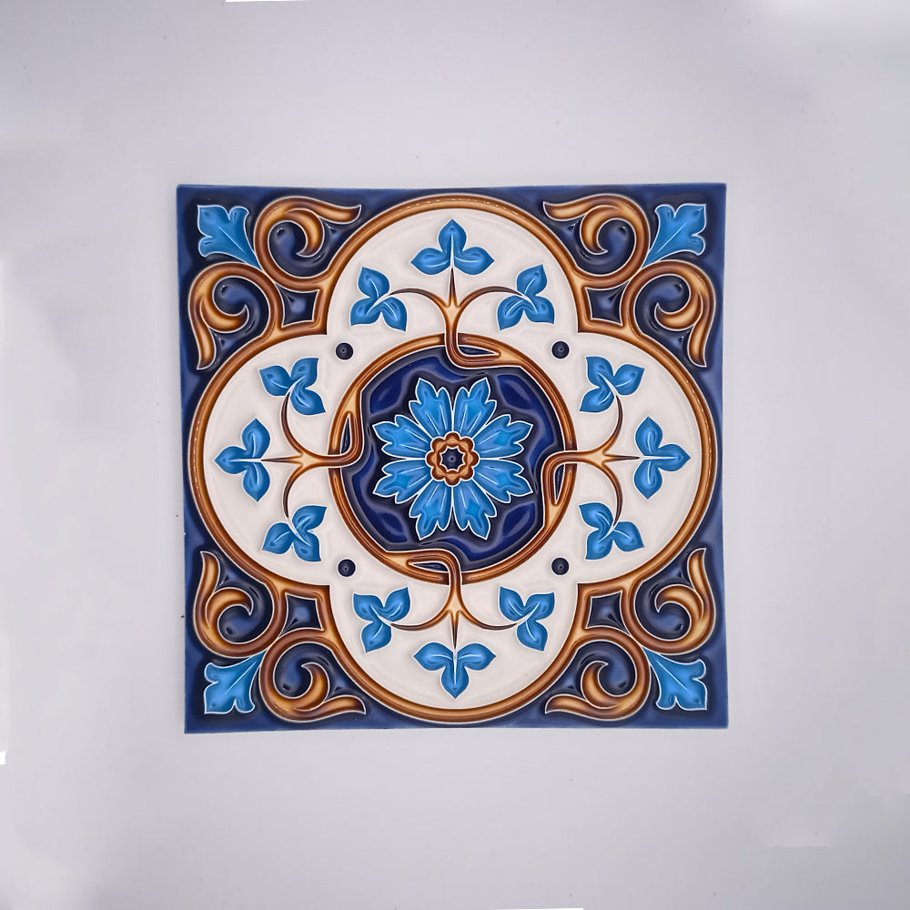 Decorative hand-painted ceramic tile featuring a symmetrical design with a central blue flower surrounded by blue and golden floral patterns on a white background from Tejo Shop's Royals Decor Blacksplash Tile.
