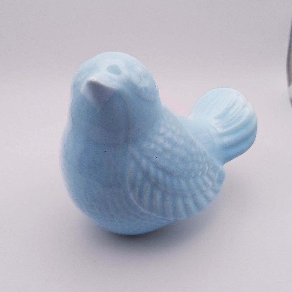 A small, handmade light blue Ceramic Bird looking up Figurine from Tejo Shop with intricate feather detailing sits against a plain white background. The bird is facing slightly to the right, making it an exquisite piece of home decor.