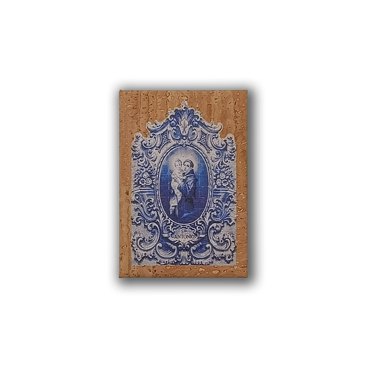 A decorative Saint Anthony cork fridge magnet by New Jamp is mounted on a tan wall in Lisbon, capturing true Portuguese charm with visible water droplets.