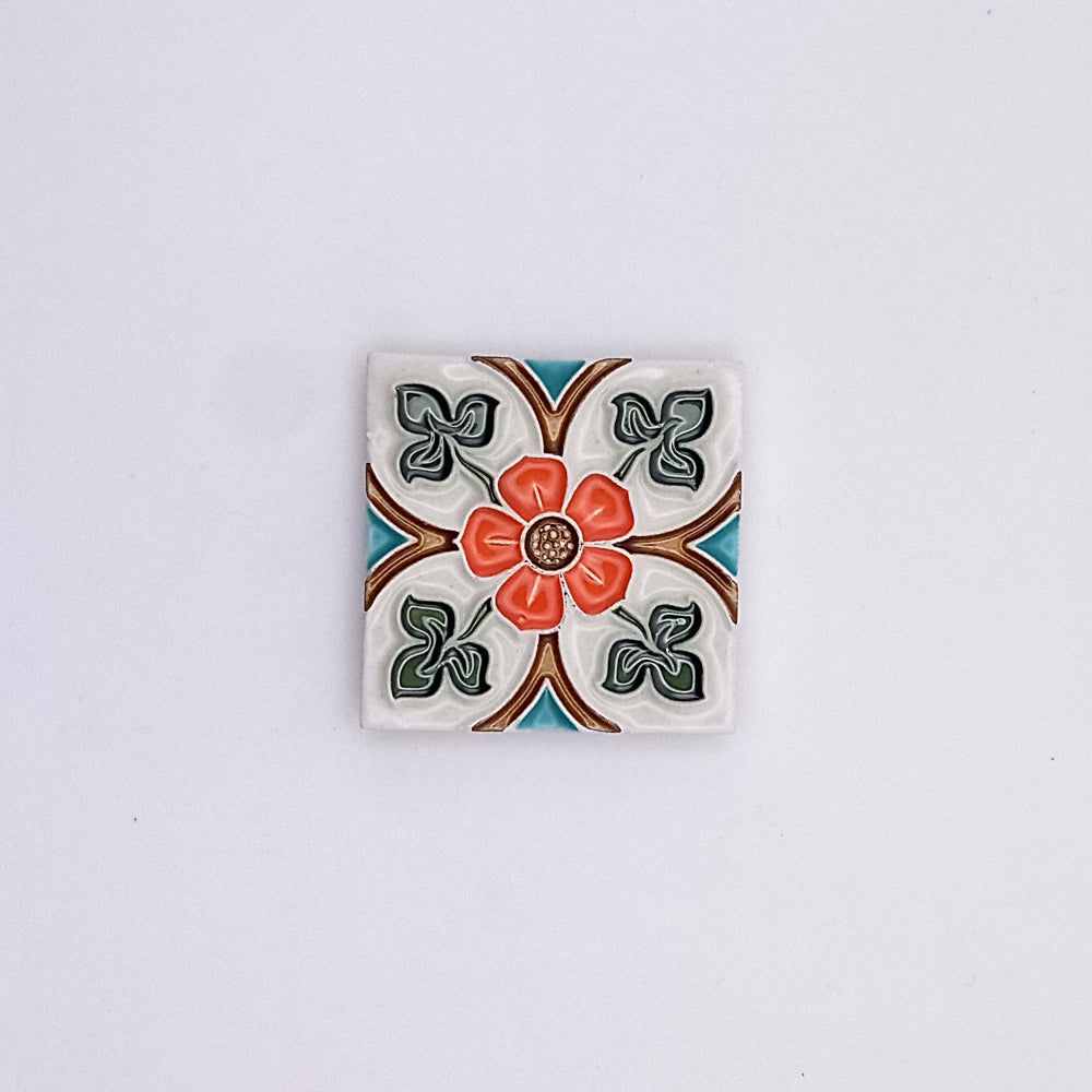 Decorative Exclusive Small Ceramic Tile from Tejo Shop with a colorful floral pattern, featuring a central red flower surrounded by green leaves and orange accents, set against a white background.