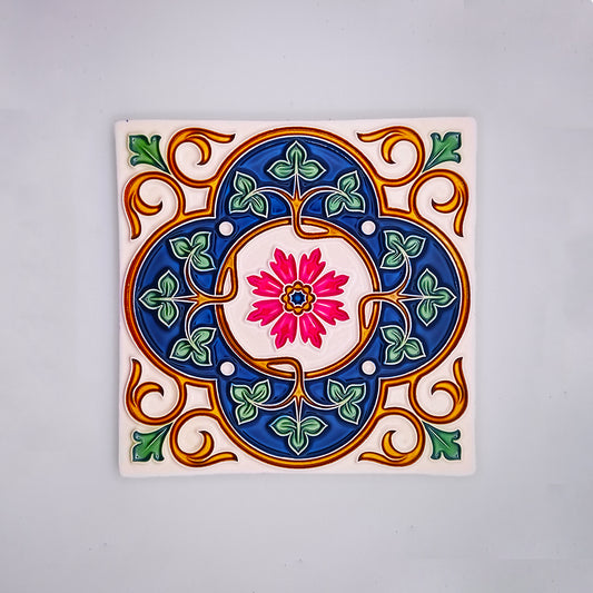 Colorful hand-painted Tejo Shop Mediterranean Kitchen Tile with a symmetrical floral design in vibrant blue, pink, green, and yellow, set against a white background.