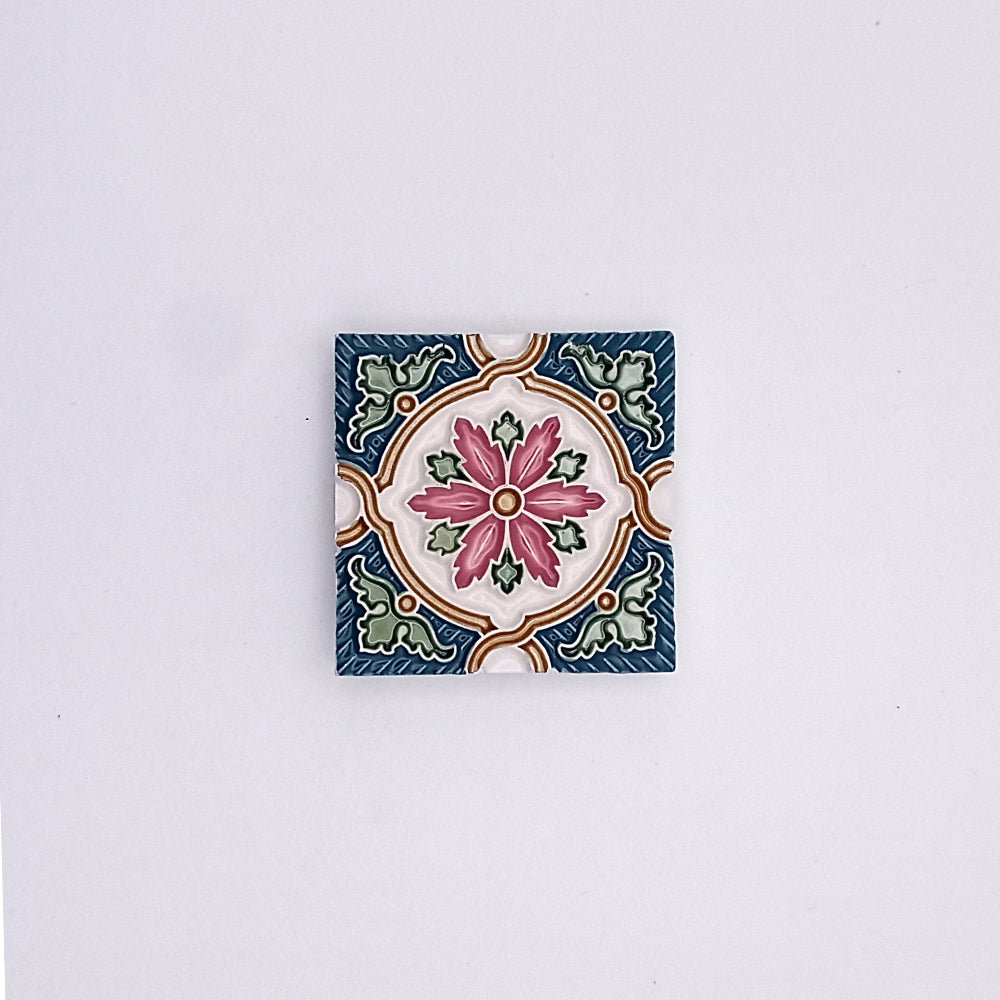 Decorative square ceramic tile with Portuguese-inspired designs, featuring Historic Green Small Ceramic Tiles from Tejo Shop, with a central pink flower surrounded by green leaves and intricate blue borders, isolated on a plain white background.