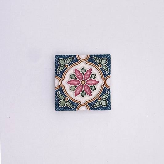 Decorative square ceramic tile with Portuguese-inspired designs, featuring Historic Green Small Ceramic Tiles from Tejo Shop, with a central pink flower surrounded by green leaves and intricate blue borders, isolated on a plain white background.