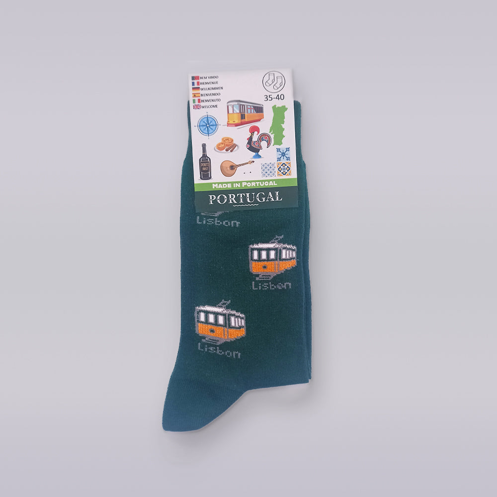 Introducing the Socks - Portuguese 2D Trams by Tejo Shop: a single dark green sock adorned with charming embroidered designs of Lisbon trams. The packaging showcases delightful Lisbon-themed illustrations such as a tram, custard tart, rooster, and a map of Portugal. Crafted from premium cotton, these socks fit sizes 35-40 and proudly display the "Made in Portugal" label. Add a quirky touch to your wardrobe with these unique socks!