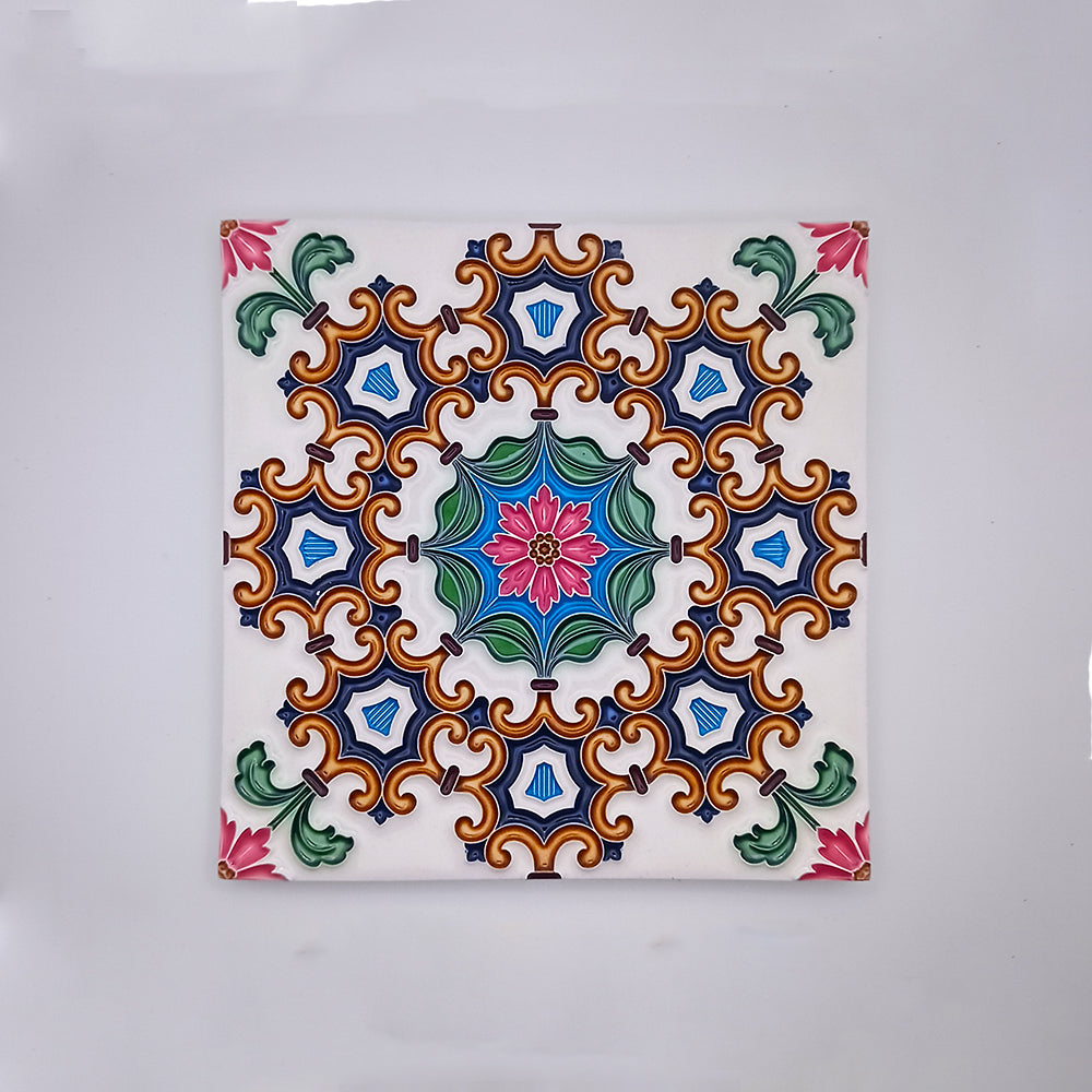 A square Tejo Shop Belém Painted Ceramic Tile featuring a symmetrical pattern with stylized floral and geometric shapes in vibrant colors of blue, orange, green, and pink on a white background.