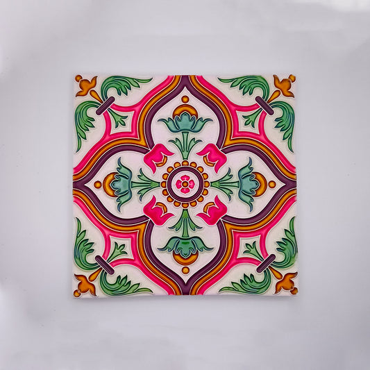 A colorful hand-crafted Spanish Tile Pattern from Tejo Shop with a symmetrical floral pattern, featuring pink, green, yellow, and orange accents on a white background.