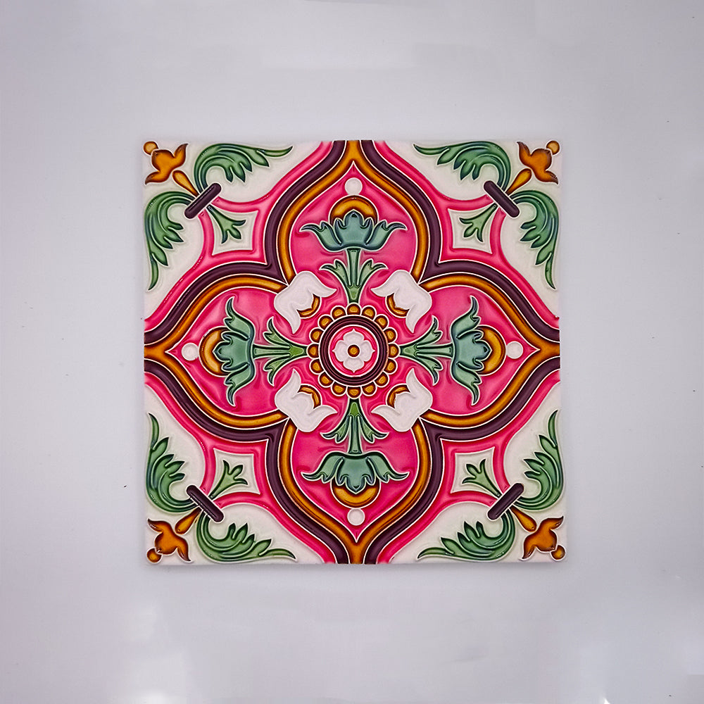 A vibrant ceramic tile featuring a symmetrical floral design in shades of pink, green, and orange, highlighted with white accents, all against a pale background. This Tejo Shop Spanish Wall Tile is perfect for enhancing any bathroom.