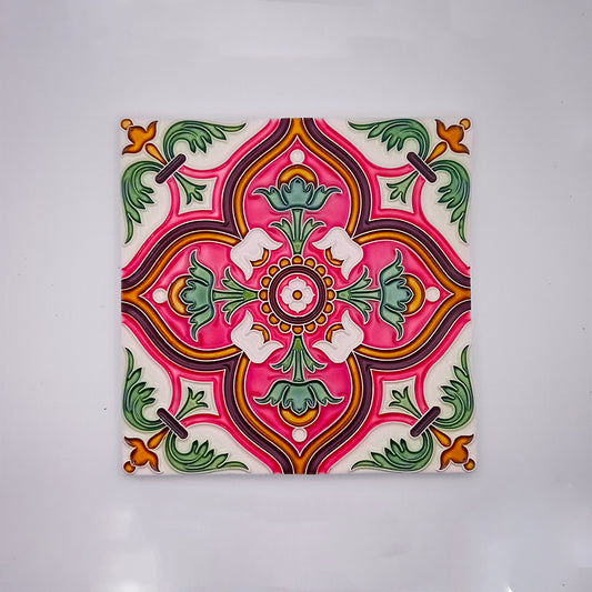 A vibrant ceramic tile featuring a symmetrical floral design in shades of pink, green, and orange, highlighted with white accents, all against a pale background. This Tejo Shop Spanish Wall Tile is perfect for enhancing any bathroom.