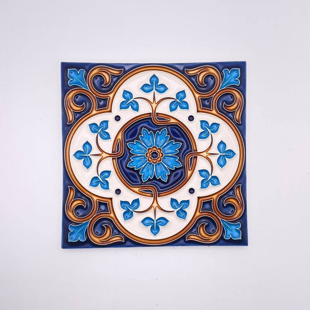 A Madeira Decor Tile from Tejo Shop featuring a symmetrical design with a central floral motif in shades of blue, surrounded by intricate gold and blue patterns, on a white background.