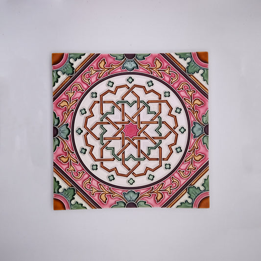 Decorative handcrafted Faro Wall Tile Decor featuring a symmetrical geometric pattern in shades of pink, green, and white, set against a plain gray background from Tejo Shop.